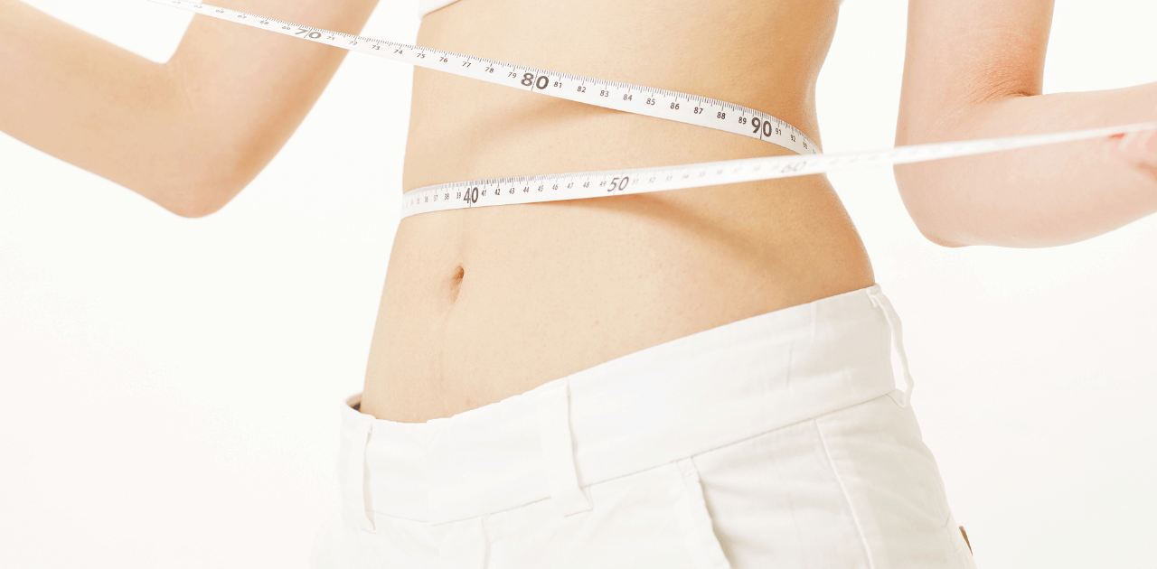 ダイエットするためにウエストを計っている女性の画像