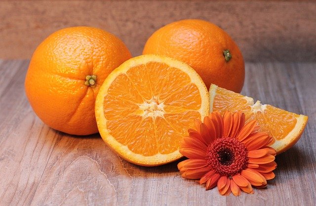真ん丸のオレンジとカットされたオレンジとお花