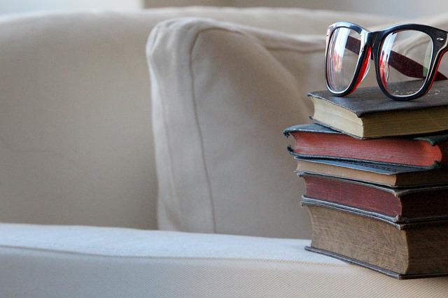 白いソファーの上に置かれた本と眼鏡