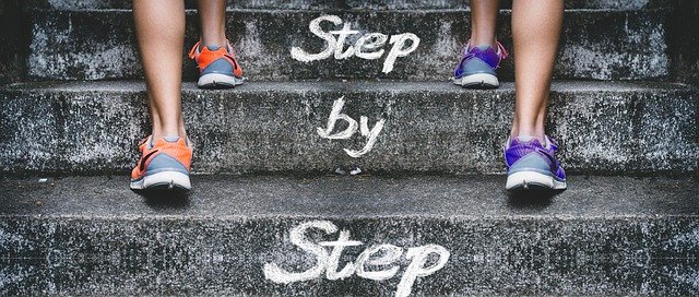 step by stepと書かれた階段と2人の足