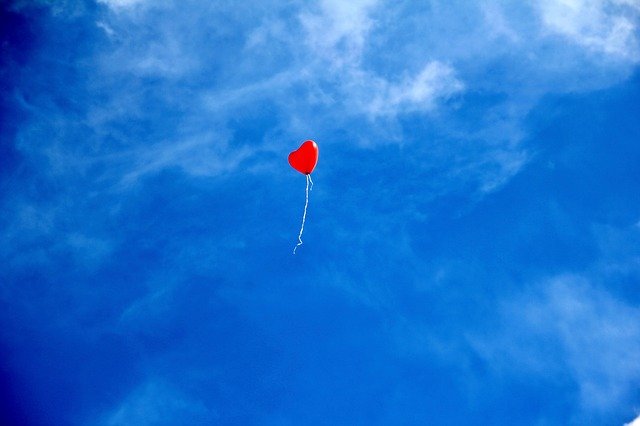 青空に浮かぶ赤いハート型の風船